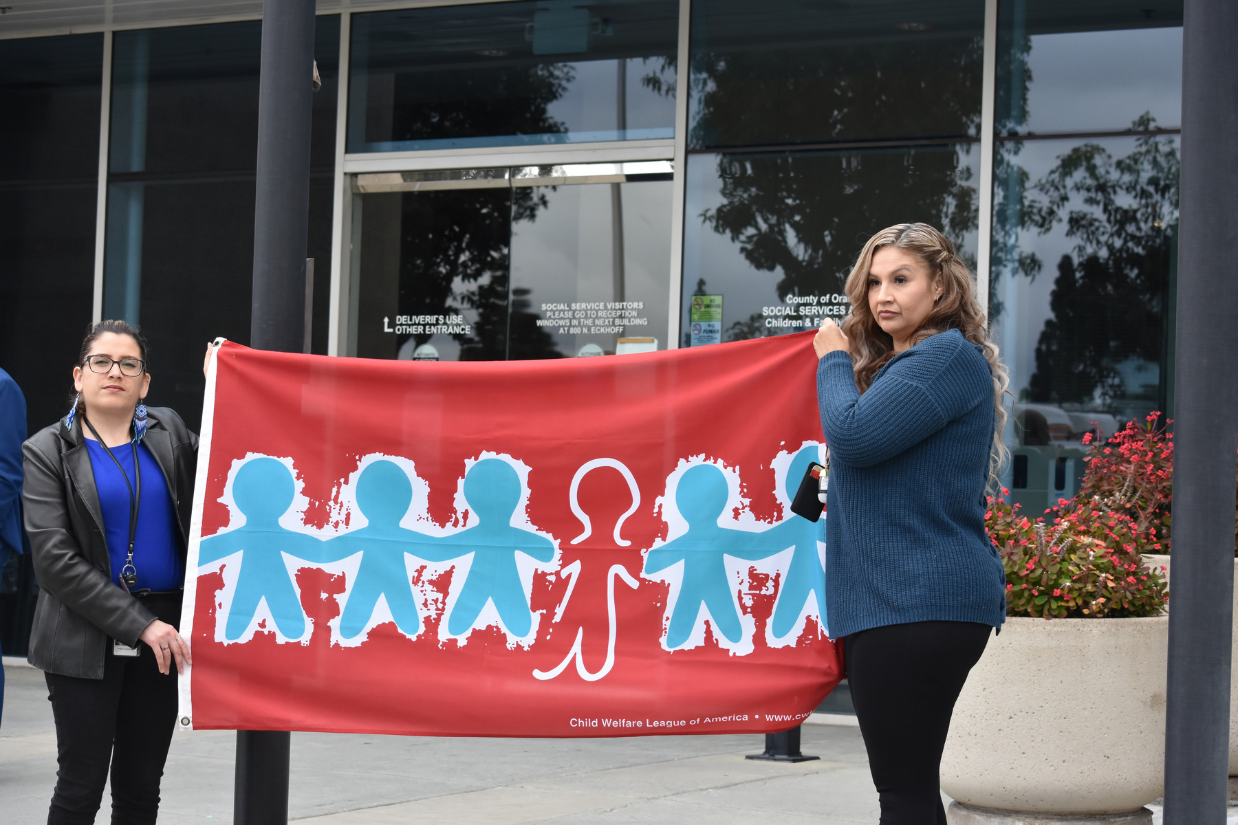 A Children and Family Services employee holds up the Children's Memorial Day Flag