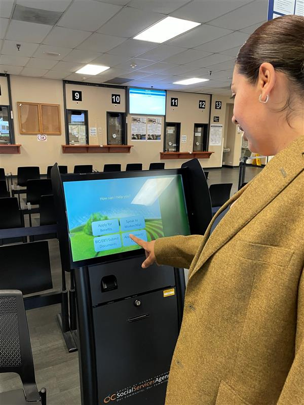 An SSA employee uses a digital kiosk to check in a customer