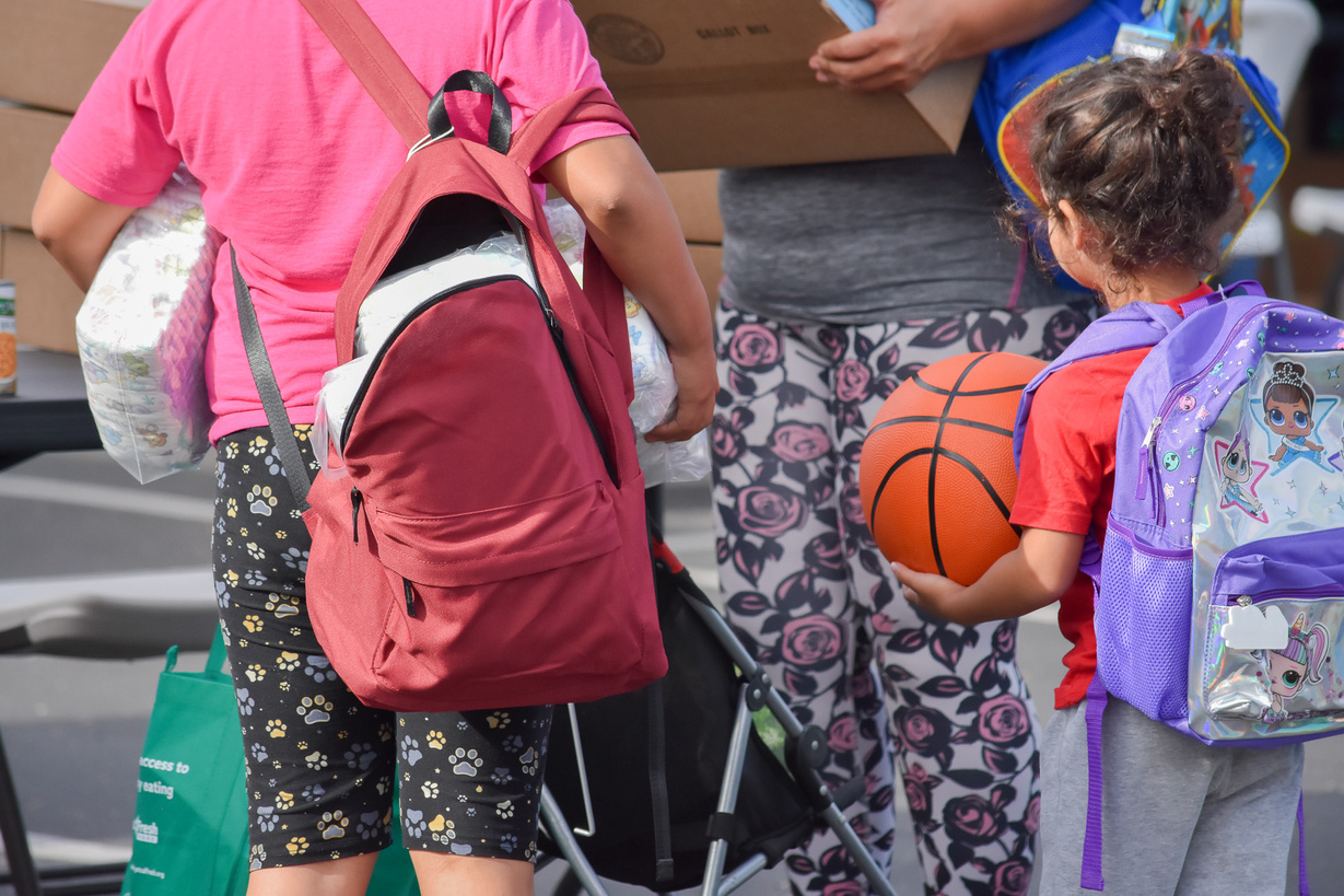 A family collects resources from a community fair hosted by the Social Services Agency