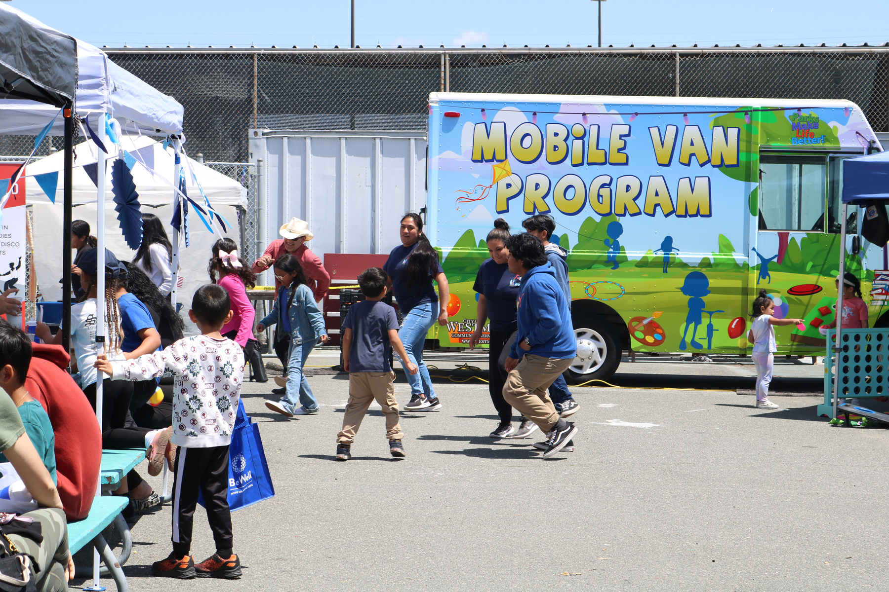 Children play in front of a Mobile Van Program bus